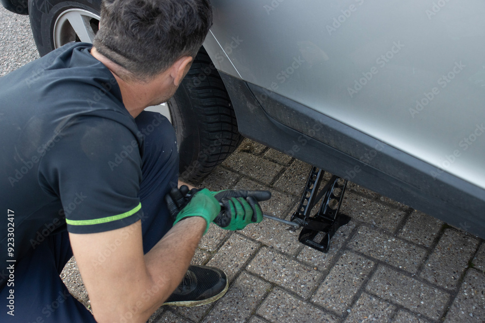 European man repairing a car. Changing a wheel. Service at a service station. Maintenance European man repairing a car. Changing a wheel. Service at a service station. Maintenance