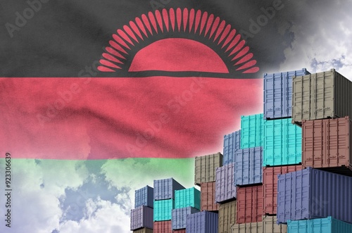 Malawi flag and big stack of shipping cargo containers in docks with sky background close up photo