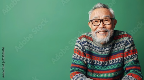 An elderly man laughs while wearing a vibrant sweater, showcasing happiness in a simple moment