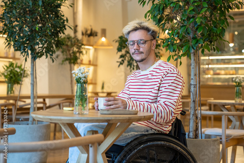 Bild auf Leinwand Thoughtful disabled guy sitting in coffee shop feels solitude, thinking about problems