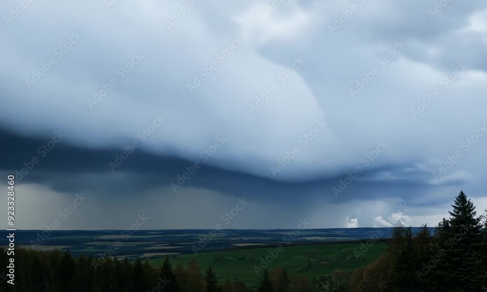 Dramatic cloudscape over a green mountain range with a winding river below Dramatic cloudscape over a green mountain range with a winding river below