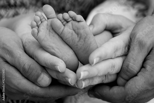 hand and feet of a young family, parents holding the baby's feet