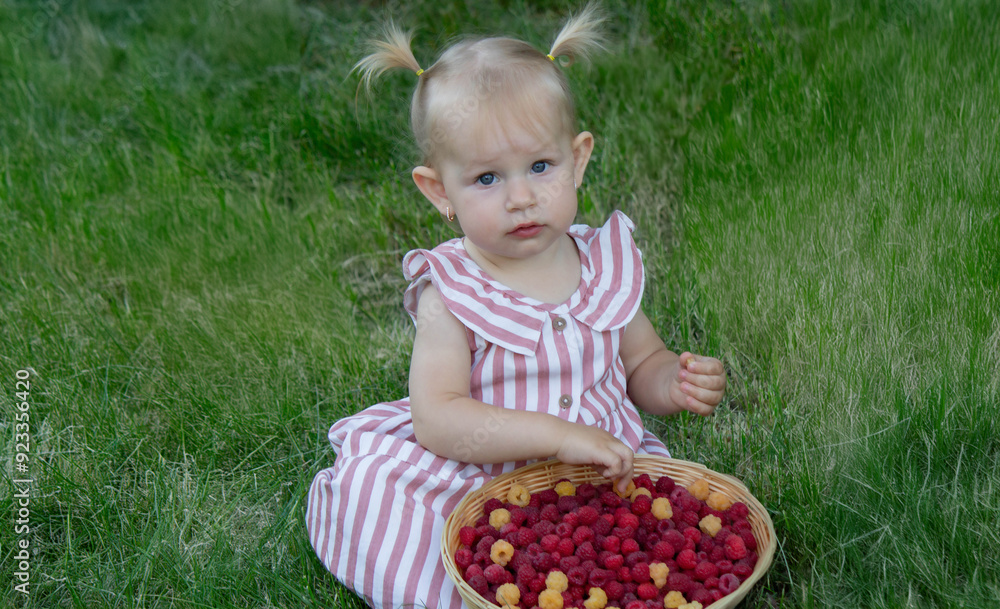 a little girl eats a raspberry. Selective focus a little girl eats a raspberry. Selective focus