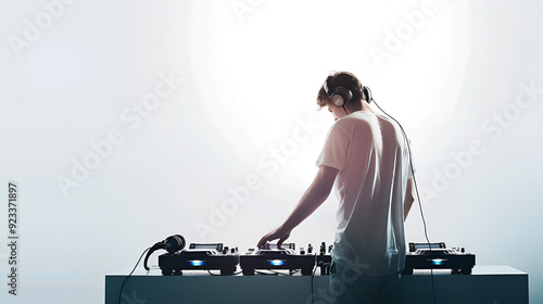 DJ operating turntables in studio with headphones on