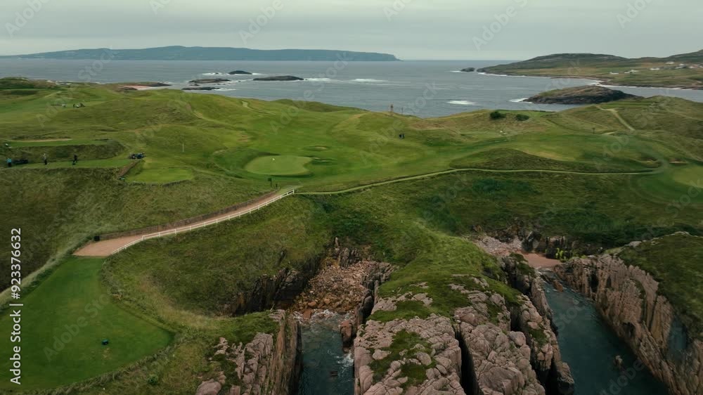 Drone orbit to reveal stunning coastline of Ireland links golf course with rolling green fairways and cliffs down to ocean Drone orbit to reveal stunning coastline of Ireland links golf course with rolling green fairways and cliffs down to ocean