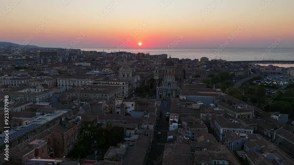 A coastal cityscape at sunset with vibrant sky and calm sea, aerial view A coastal cityscape at sunset with vibrant sky and calm sea, aerial view