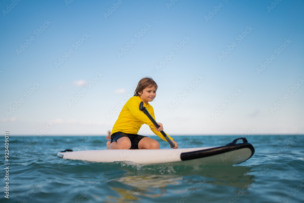 Kid and Summer sea. Child boy paddling on paddle board or sup. Summer vacation with children. Summer lifestyle. Summer Water sport. Kid Boy swimming with paddle board. Kid and Summer sea. Child boy paddling on paddle board or sup. Summer vacation with children. Summer lifestyle. Summer Water sport. Kid Boy swimming with paddle board.