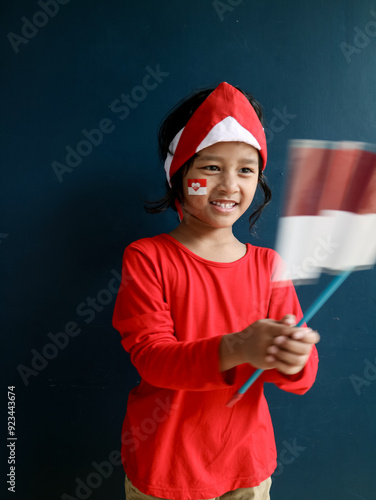 Indonesian children is holding and waving the Indonesian flag photo