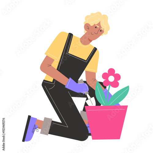 A young man sits and plants flowers in pots