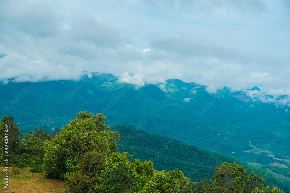 Obraz premium The sky is cloudy and the mountains are green