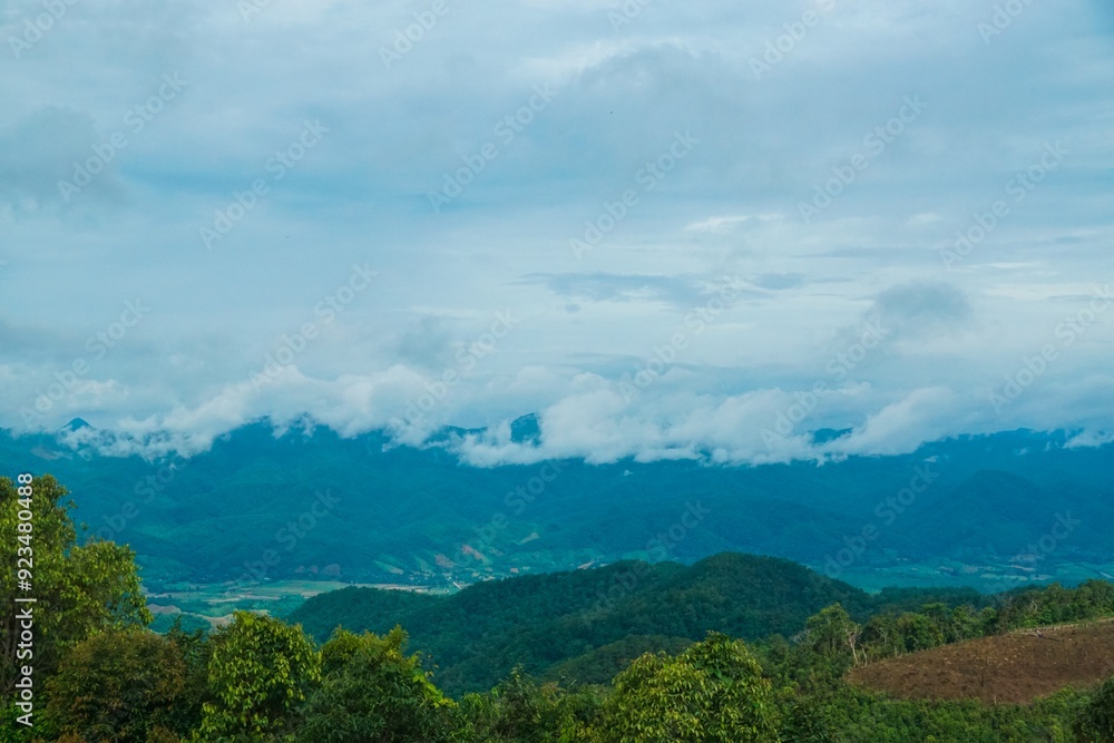 The sky is blue and cloudy, with mountains in the background