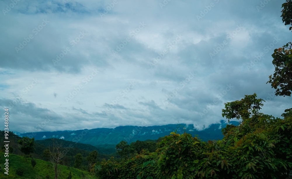 A cloudy sky with mountains in the background A cloudy sky with mountains in the background