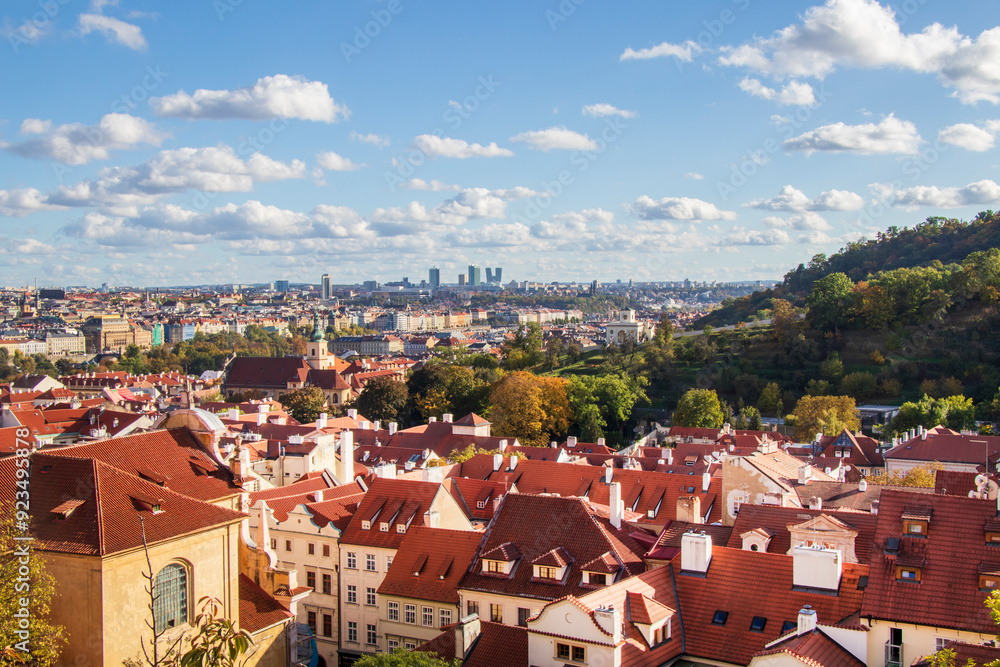 Obraz premium View of Historic Rooftops in Prague. Panoramic view of red rooftops in historic Prague under a clear blue sky, showcasing architectural charm and urban beauty.