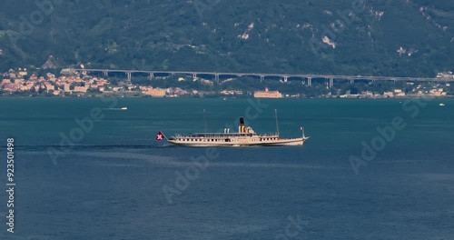 Water transport in Switzerland. Navigating a Swiss Lake. Aerial view steamboat ship on lake Interlaken. Switzerland summer tourism destination. Turquoise blue water. Swiss flag on a passenger ship photo