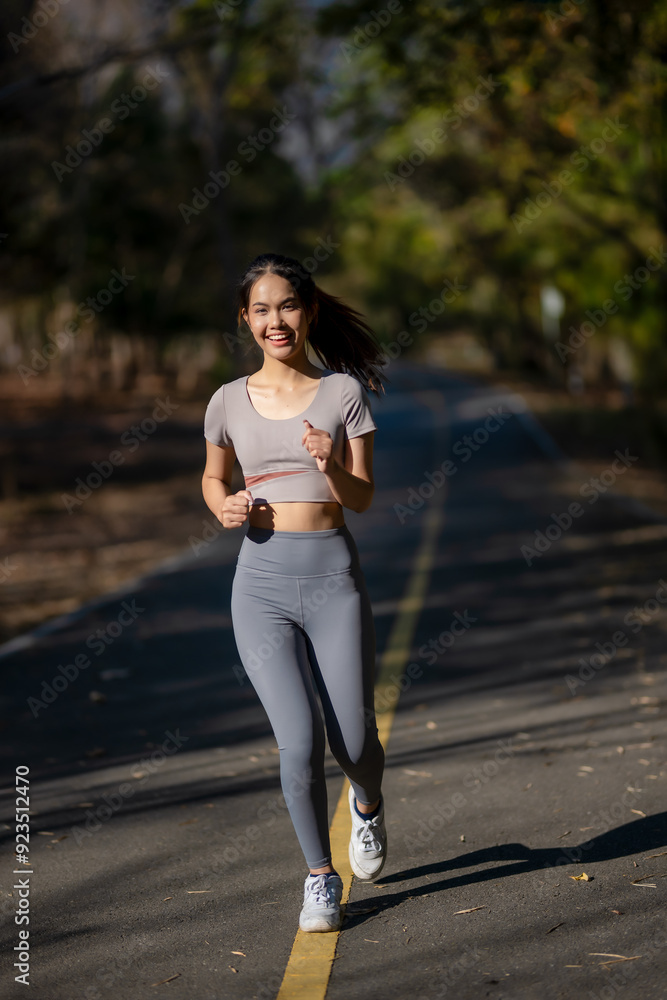A woman is running on a road with a smile on her face A woman is running on a road with a smile on her face