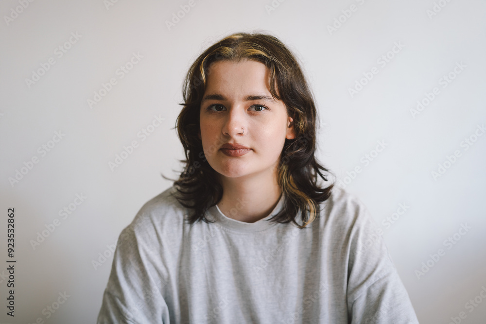 Portrait of a beautiful teenage girl with a nose piercing on a gray background Portrait of a beautiful teenage girl with a nose piercing on a gray background