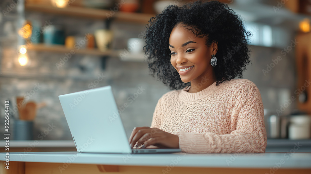 Happy black woman using laptop in the kitchen. Happy black woman using laptop in the kitchen.