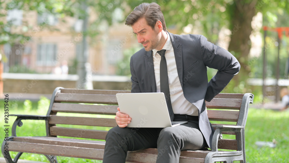 Tired Middle Aged Businessman with Back Pain Using Laptop Outdoor Tired Middle Aged Businessman with Back Pain Using Laptop Outdoor