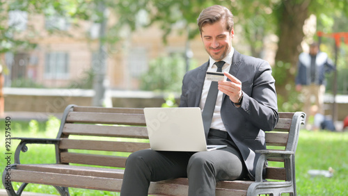 Middle Aged Businessman Enjoying Online Banking with Credit Card Outdoor