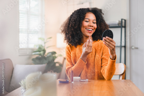 Photography Pretty woman with curly hair putting on makeup at home.