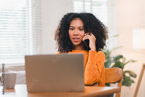 Smiling African American Woman on Phone Call at Desk While Working at Home.