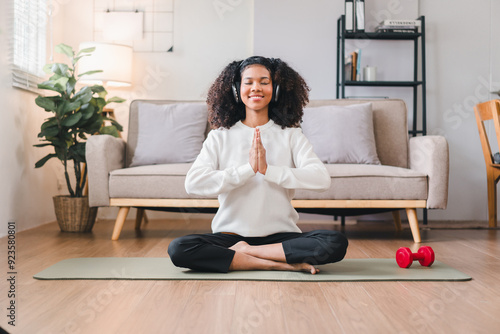 Happy African American Woman Meditating at Home with Headphones.