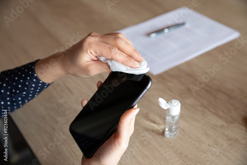 Εκτύπωση καμβά Close up top view of woman disinfect smartphone using antibacterial wipes and al