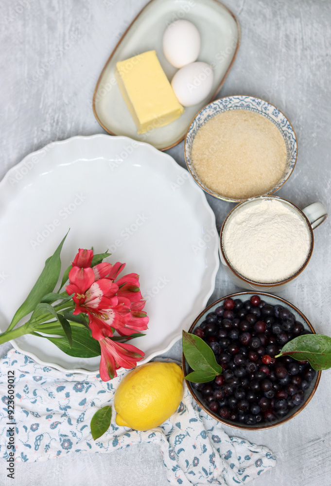 Ingredients for baking pie: flour, eggs, sugar, lemon, blueberries. Light background, top view, copy space Ingredients for baking pie: flour, eggs, sugar, lemon, blueberries. Light background, top view, copy space