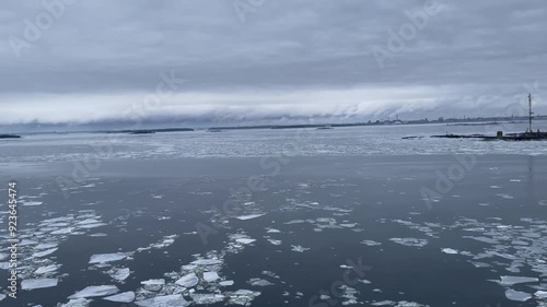 Pan from right to left of a ship sailing past the Harmaja lighthouse near Helsinki in icy waters photo