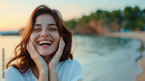 A joyful young woman with a big smile enjoying a peaceful moment at the beach during sunset, expressing happiness and contentment. photo