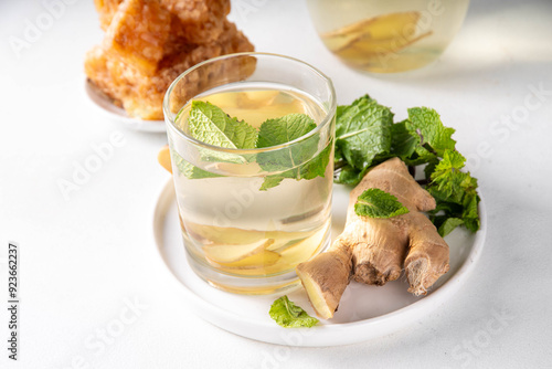 Sweet Ginger Mint Coconut Water Cooler with honey, infused ginger mojito cocktail on white table background copy space