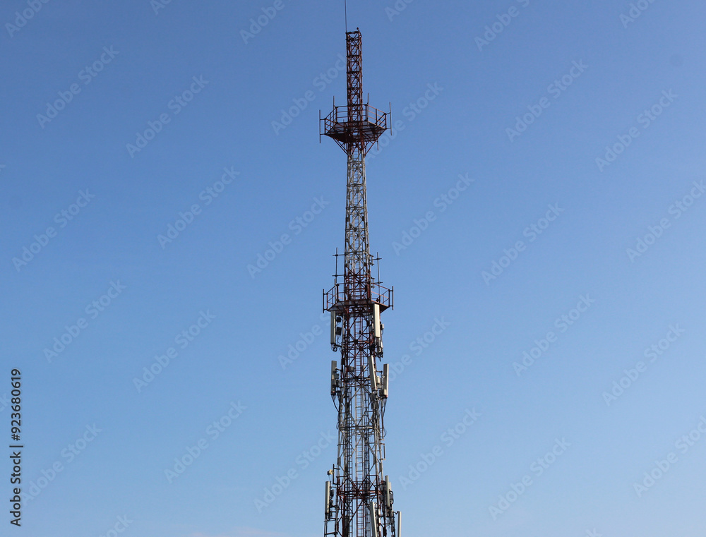 Selective focus of telecommunications towers with a background of bright blue sky with clouds during the day Selective focus of telecommunications towers with a background of bright blue sky with clouds during the day