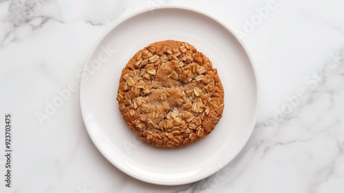 Single oatmeal cookie with visible oats on a white plate