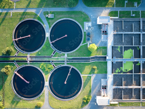 Sustainable water management theme: Aerial, top down view of industrial clarifiers in wastewater treatment plant in sunset. Elements of urban water treatment technology. 