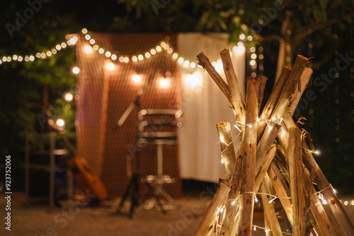 Cozy outdoor evening setup with string lights and logs.