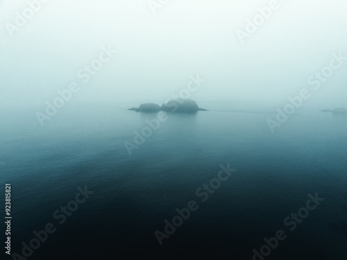 Einsame Insel im Meer umgeben von mystischen regnerischen Nebel von Nordirland Sheep Island photo