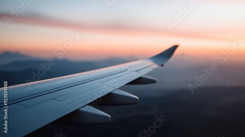 The wing of an airplane majestically glides over a blanket of clouds during a beautiful sunset, capturing the serene and adventurous spirit of air travel.