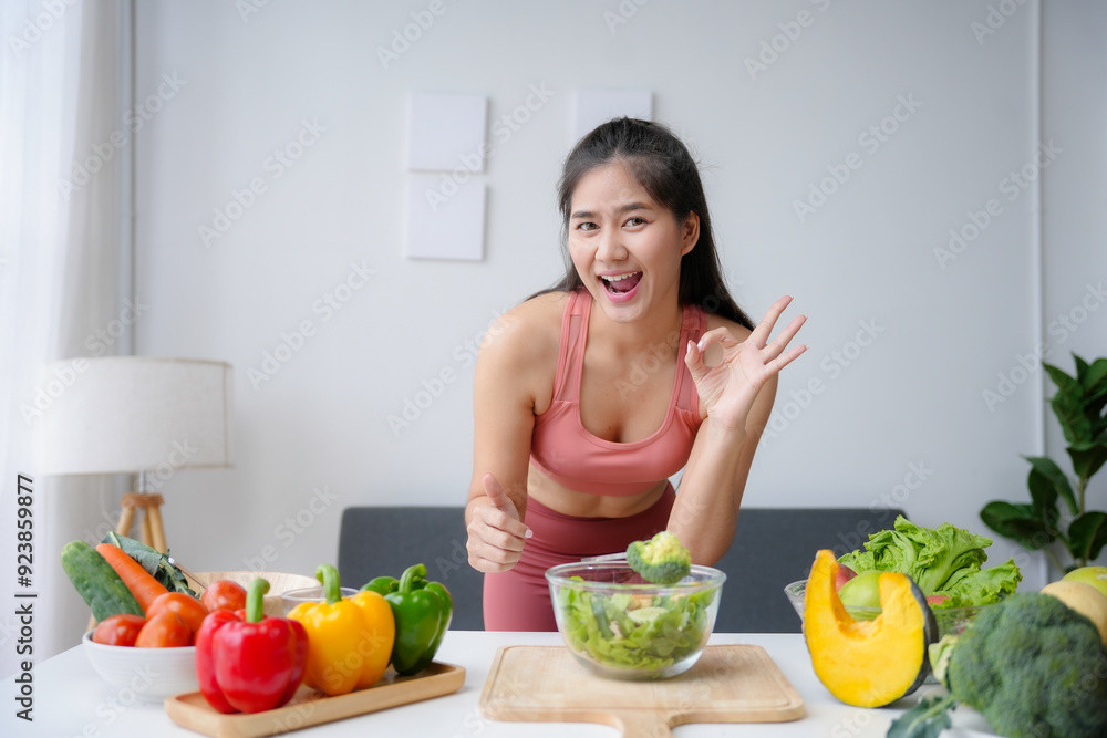 Young smiling sport woman showing ok sign while preparing healthy vegetable salad in the kitchen Young smiling sport woman showing ok sign while preparing healthy vegetable salad in the kitchen