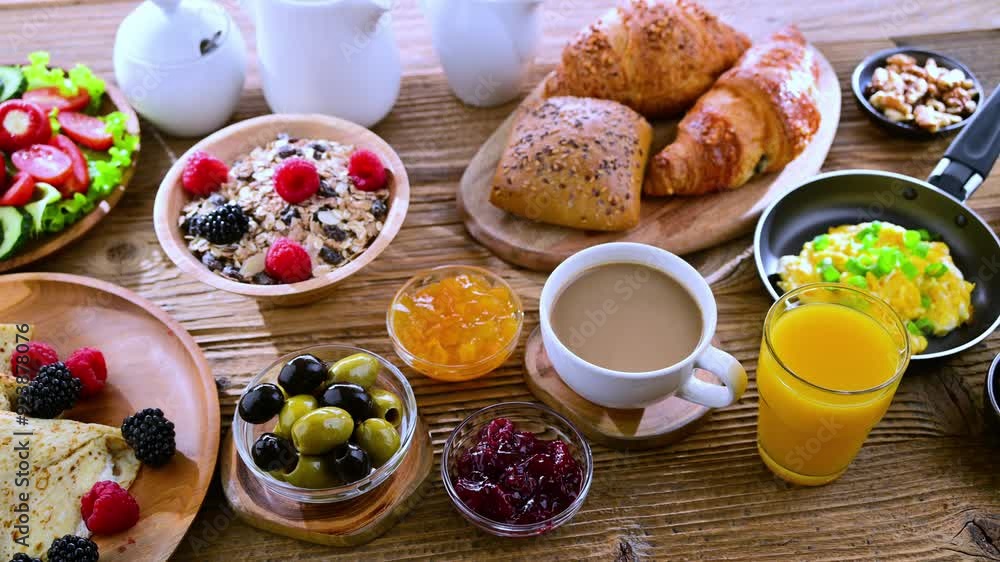 Breakfast served with coffee, orange juice, croissants, cereals, scrambled eggs and pancakes.