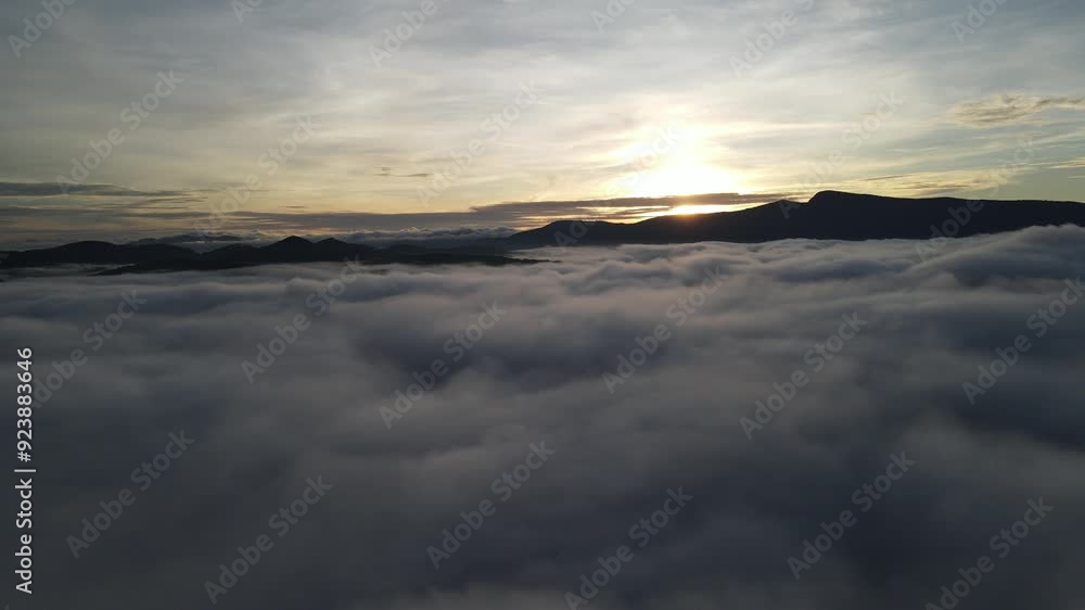 Aerial view of clouds flowing with mountains in the background Aerial view of clouds flowing with mountains in the background