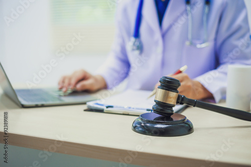 The hammer of justice is a law protecting doctors in diagnosing patients and leading to their death. Hospital insurance considers safety in judgment with lawyers, judges, courts, copy space.