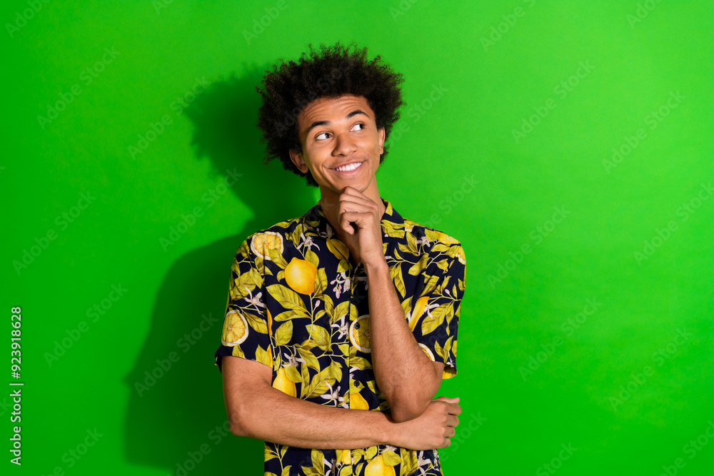 Photo of smiling guy touch chin look up thinking isolated green bright color background Photo of smiling guy touch chin look up thinking isolated green bright color background