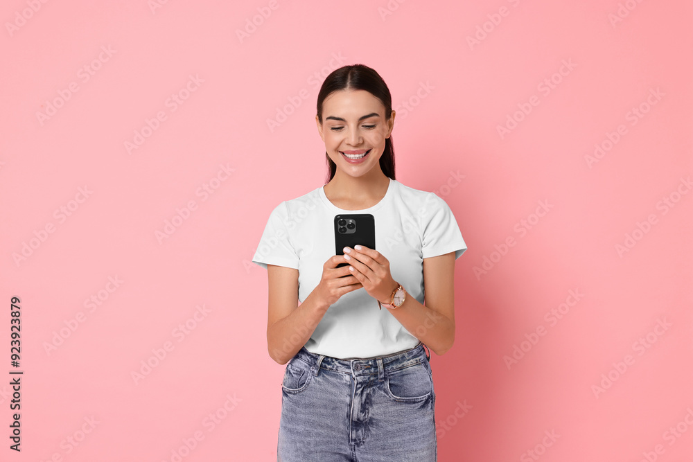 Smiling woman with smartphone on pink background Smiling woman with smartphone on pink background