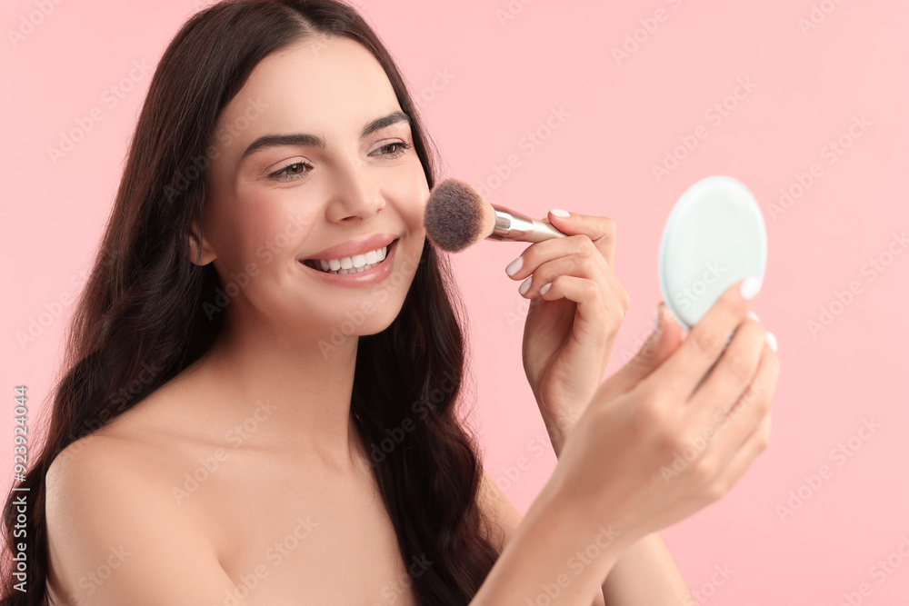 Beautiful makeup. Smiling woman applying blush with brush on pink background Beautiful makeup. Smiling woman applying blush with brush on pink background