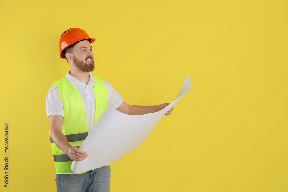 Engineer in hard hat with draft on yellow background, space for text Engineer in hard hat with draft on yellow background, space for text