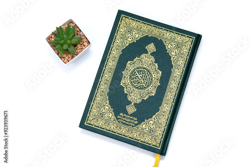 a hand pointing to the Muslim holy book al quran isolated on a white background with plants