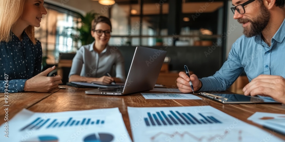 A financial advisor and a couple discussing their retirement plan, with charts, documents, and a laptop on the table in a modern office A financial advisor and a couple discussing their retirement plan, with charts, documents, and a laptop on the table in a modern office