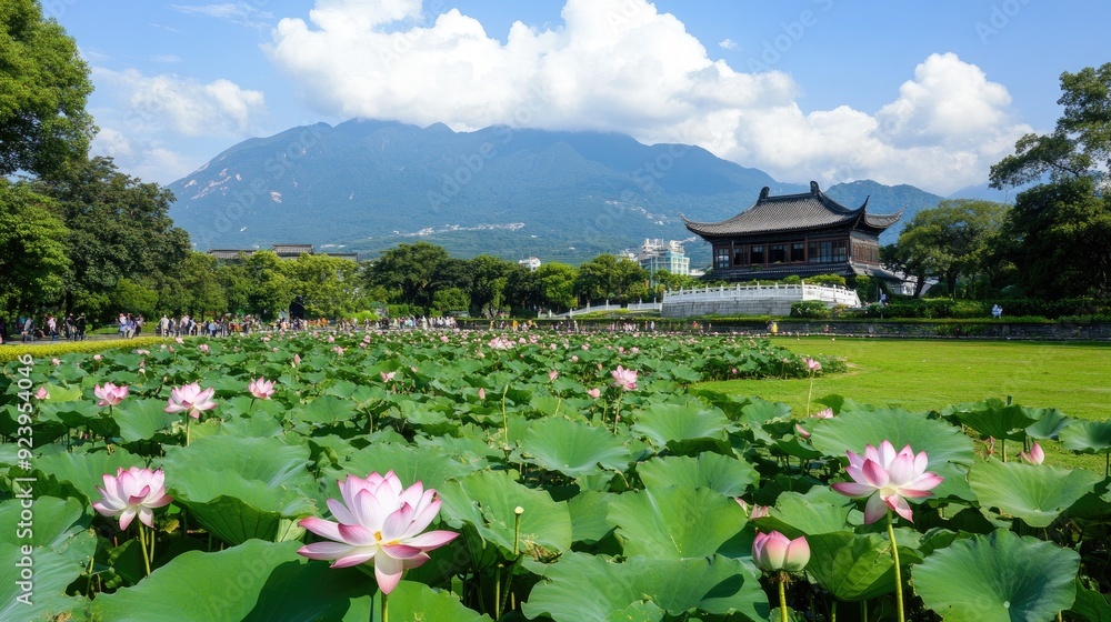Lotus flowers bloom vibrantly in the garden, complemented by a distant ancient building and lush greenery against a backdrop of mountains and a bright blue sky Lotus flowers bloom vibrantly in the garden, complemented by a distant ancient building and lush greenery against a backdrop of mountains and a bright blue sky