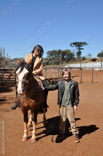 mãe e filho juntos em cavalgada com cavalo  photo