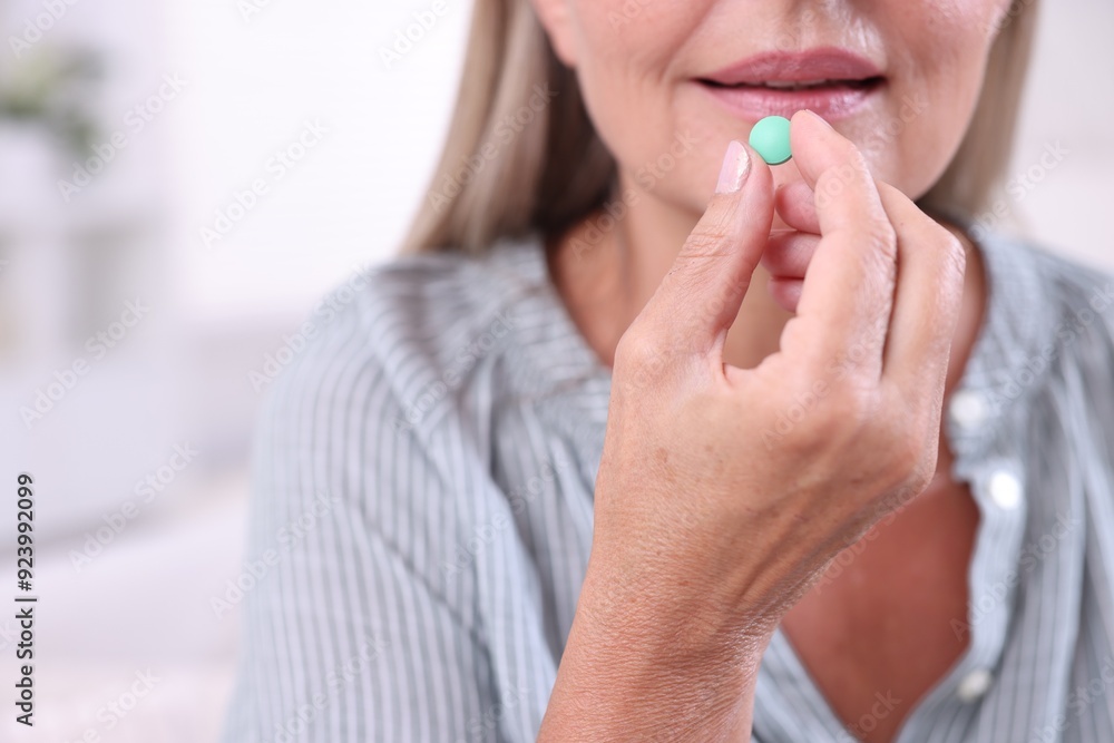 Senior woman taking pill at home, closeup Senior woman taking pill at home, closeup